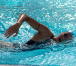 mujer en piscina nadando contracorriente