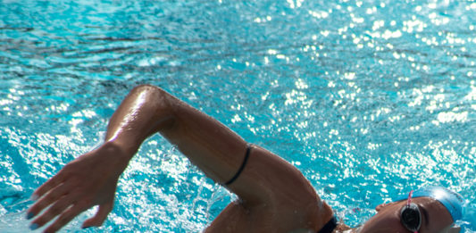 mujer en piscina nadando contracorriente